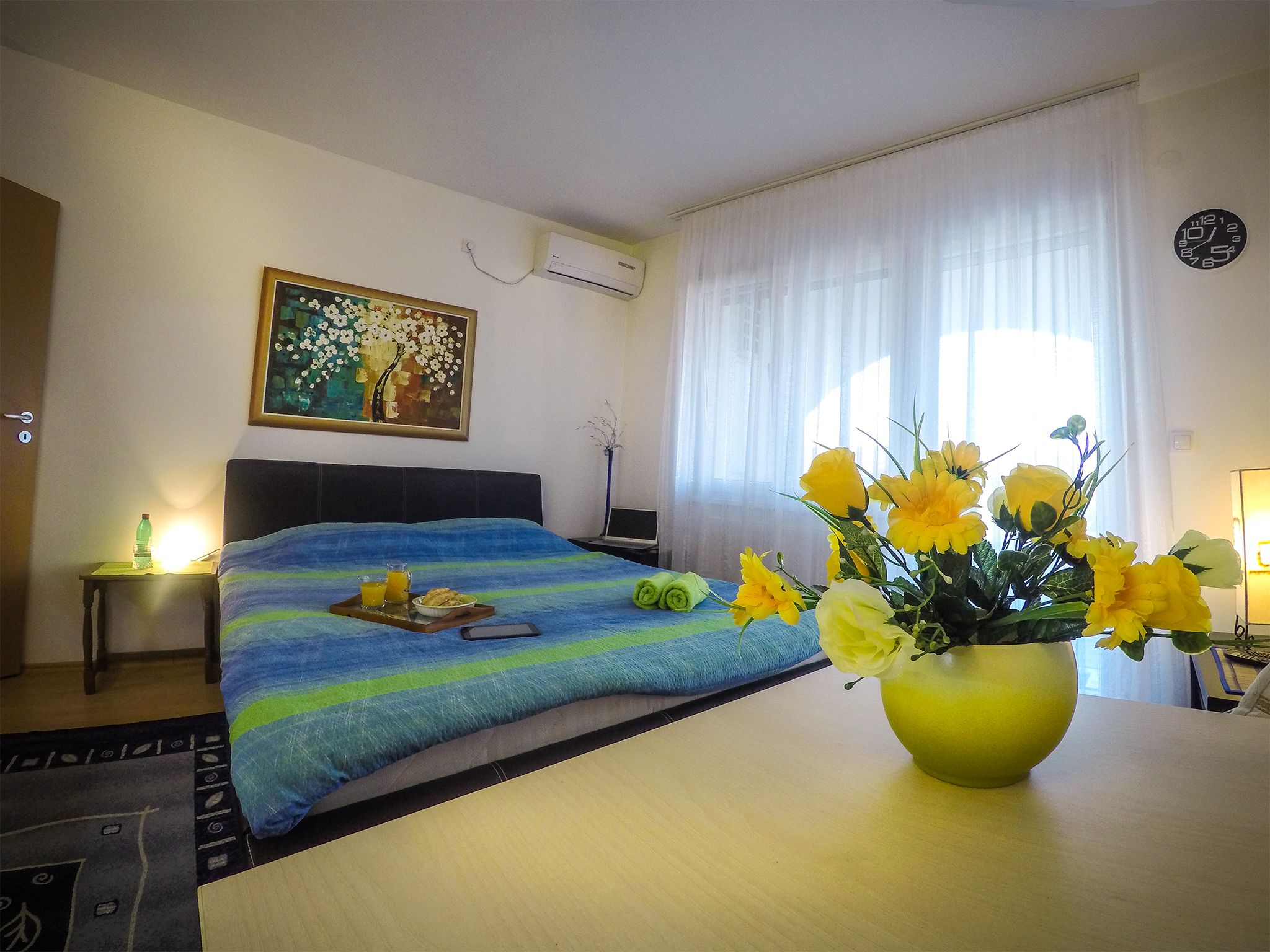 Apartman Konstantin, bračni krevet i cveće na stolu